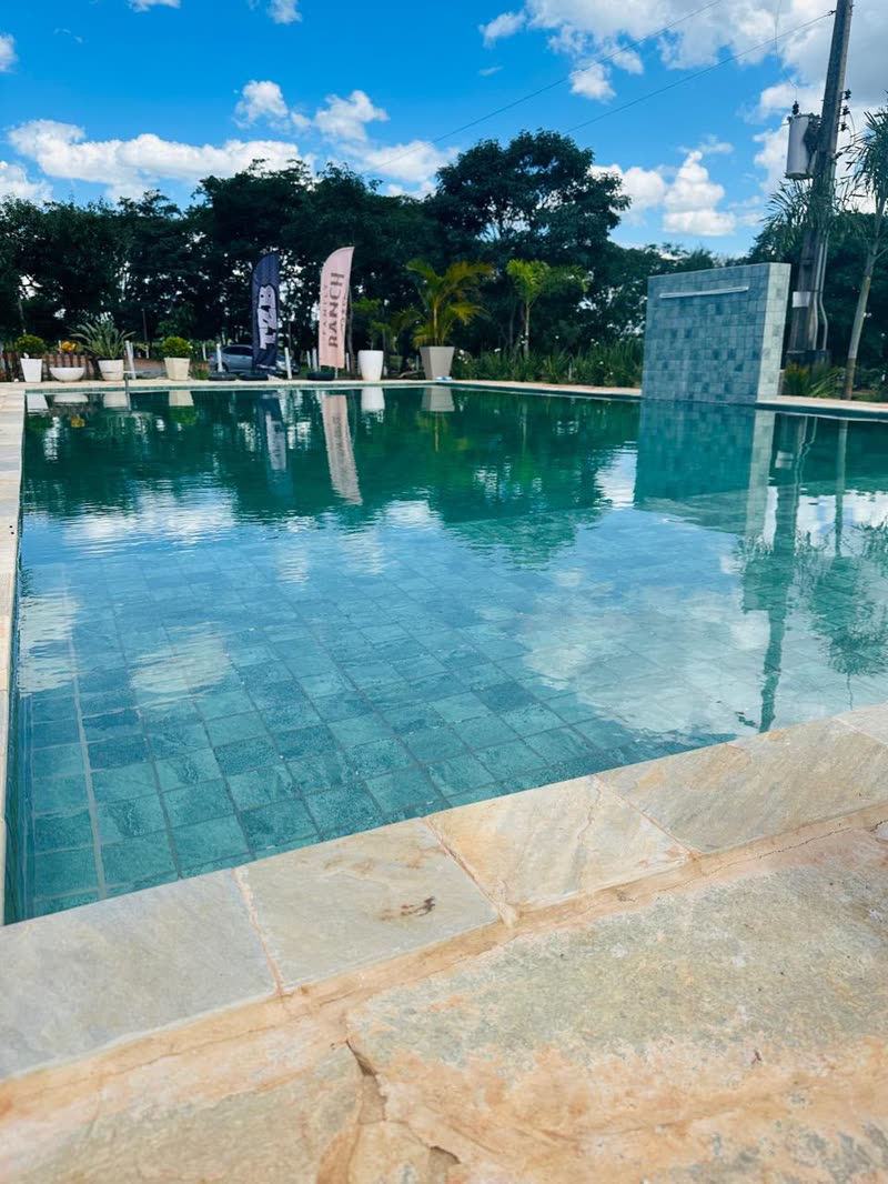 Piscina com borda de pedra e água esverdeada